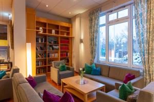 a living room with couches and a book shelf at Golfhotel Fahrenbach in Tröstau