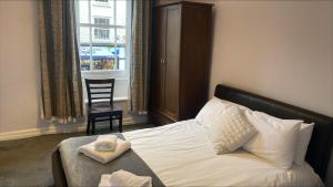 a bedroom with a bed and a chair and a window at The Pack Horse in Louth +16 photos