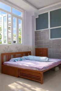 a large bed in a room with two windows at Nature House Homestay in Ho Chi Minh City