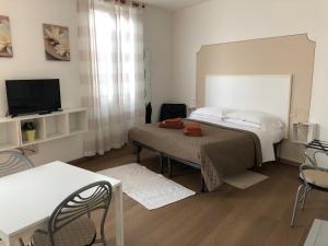 a bedroom with a bed and a table and a tv at Residence Gloria in Montecatini Terme