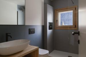 a bathroom with a white sink and a toilet at Hotel Chalet Rezia in Chiesa in Valmalenco +16 photos