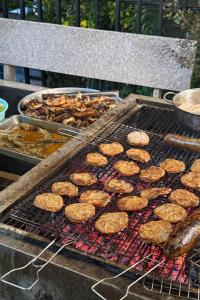 a grill with hamburgers and other food on it at Nature House Homestay in Ho Chi Minh City +39 photos