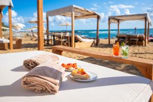 a table with plates of food on the beach at Pietrablu Resort & Spa - CDSHotels in Polignano a Mare