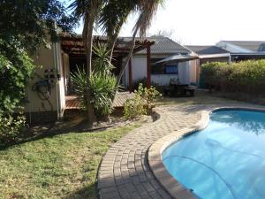 a swimming pool in a yard next to a house at African Oasis Morrocco in Somerset West