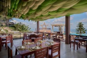 a restaurant with tables and chairs and a view of the ocean at Romhaey Kirirom Resort by EHM in Phumĭ Péam Lvéa