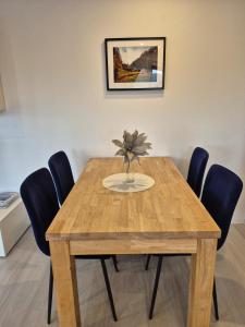 a wooden table with chairs and a vase on it at Ferienwohnung Familie Aestel in Altensteig
