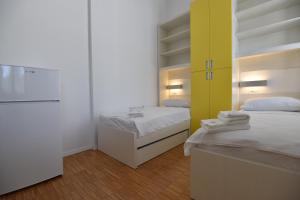 a small room with two beds and a refrigerator at SC Pula Rooms & Studio in Pula +83 photos