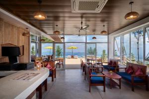 a restaurant with tables and chairs and a view of the ocean at Romhaey Kirirom Resort by EHM in Phumĭ Péam Lvéa