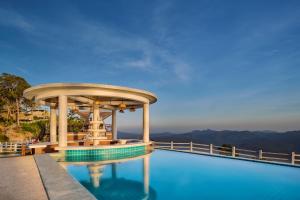 a swimming pool with a building on top of a mountain at Romhaey Kirirom Resort by EHM in Phumĭ Péam Lvéa