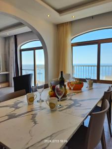 a dining room with a table with wine glasses at Seafront 3 bed Panoramic SeaViews Apt B7- in Qbajjar