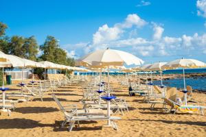 a bunch of chairs and umbrellas on a beach at Pietrablu Resort & Spa - CDSHotels in Polignano a Mare
