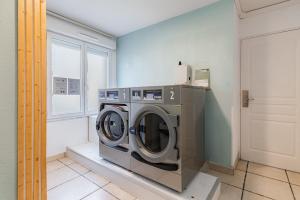 a washing machine in a laundry room with a window at Appart'City Classic Dijon - Toison D'Or in Ahuy +14 photos