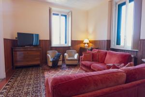 a living room with a couch and a tv at Villa Guardini - Lago di Como in Varenna