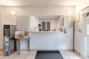 a kitchen with a refrigerator and a table in a room at Appart'City Classic Dijon - Toison D'Or in Ahuy