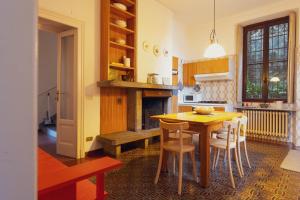 a kitchen with a table and chairs and a fireplace at Villa Guardini - Lago di Como in Varenna