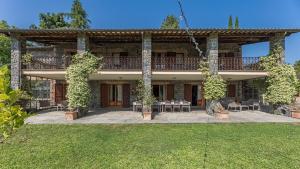 a large house with a patio with tables and chairs at Casa Andrea 12 in Orvieto