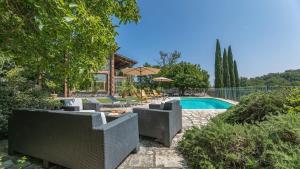 a backyard with a pool and chairs and a house at Casa Andrea 12 in Orvieto