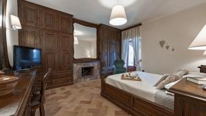 a bedroom with a bed and a desk and a television at Casa Andrea 12 in Orvieto