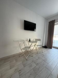 ein Zimmer mit einem Tisch, zwei Stühlen und einem Fernseher in der Unterkunft Levodr in Weljatyn