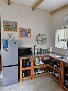 a kitchen with a refrigerator and a counter at Cosy cottage on Cassia in Gqeberha +5 photos
