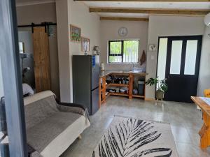 a living room with a couch and a refrigerator at Cosy cottage on Cassia in Gqeberha