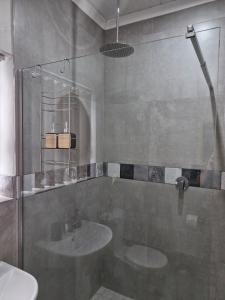 a bathroom with a glass shower and a sink at Cosy cottage on Cassia in Gqeberha