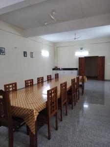 a dining room with a table and chairs and a room with a projector at Bridgettine Paradise in Sultan Bathery
