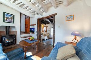 a living room with a blue couch and a fireplace at El Gato Negro in Capileira