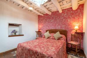 a bedroom with a bed with a red bedspread at El Gato Negro in Capileira