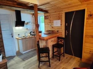 a kitchen with a counter and chairs in a cabin at Vintage House in Augustów