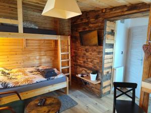 a bedroom with a bed and a wooden wall at Vintage House in Augustów