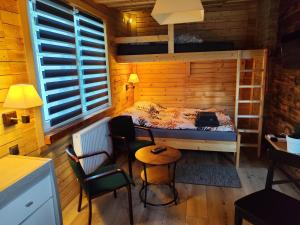 a small room with a bed and a table and chairs at Vintage House in Augustów