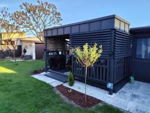 a black shed with a tree in the yard at Vintage House in Augustów