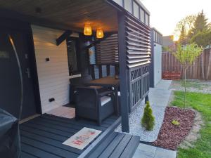 a small house with a bench on a porch at Vintage House in Augustów