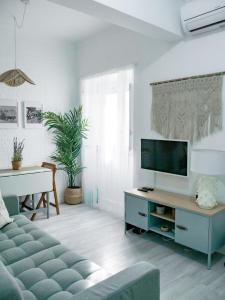 a living room with a couch and a tv at Alcácer do Sal Hideaway in Alcácer do Sal