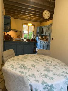 eine Küche mit einem Tisch und einer Uhr an der Wand in der Unterkunft Suite Étoile in Villebon-sur-Yvette