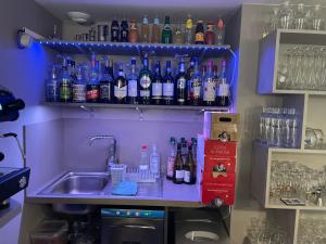a bar with a sink and a bunch of bottles at La Table du Musée in Saint-Bonnet-le-Troncy
