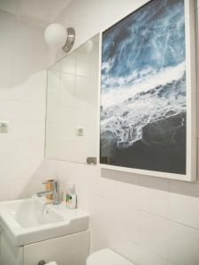 a bathroom with a sink and a painting on the wall at Alcácer do Sal Hideaway in Alcácer do Sal +32 photos
