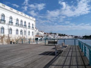 a wooden pier with two benches next to a building at Alcácer do Sal Hideaway in Alcácer do Sal