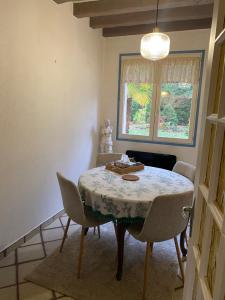ein Esszimmer mit Tisch und Stühlen und einem Fenster in der Unterkunft Suite Étoile in Villebon-sur-Yvette