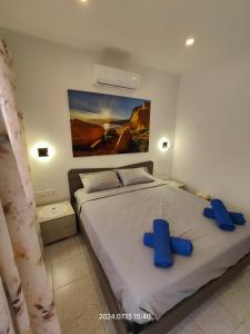 a bedroom with a bed with blue crosses on it at Seafront 3 bed Panoramic SeaViews Apt B7- in Qbajjar