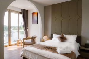 a bedroom with a large bed with a large window at Petit Hotel in Thu Dau Mot +70 photos