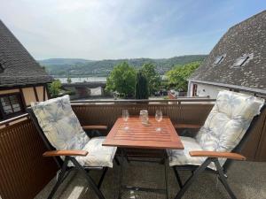 a wooden table and two chairs on a balcony at Ferienwohnung Fine in Lorch am Rhein
