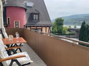 a balcony with a wooden table and a pink house at Ferienwohnung Fine in Lorch am Rhein +4 photos
