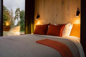 a bedroom with a bed with orange pillows and a window at CR x Rae Golf in Suuresta