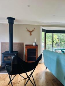 a black chair in a living room with a stove at Casa Lonita - Indoor Pool & Spa in Beechworth