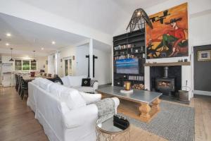 a living room with white furniture and a fireplace at Malakoff House - Charm & Luxury in Beechworth