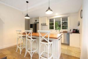 a kitchen with a counter and bar stools in it at Malakoff House - Charm & Luxury in Beechworth