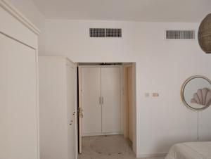 a white room with a door and a mirror at Elegant Double Room in Abu Dhabi