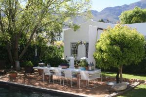 a table and chairs in front of a house at The Cottage on 55 in Franschhoek